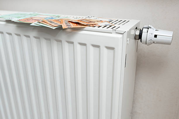 istock Banknotes placed on a white radiator, symbolizing warmth and value, representing financial matters and home economics. Ideal for concepts related to money management and household budgeting. 2251445165
