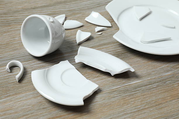 istock White cup and plate broken on wooden background 2251449264