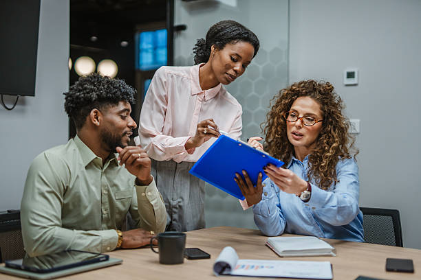 istock Business colleagues collaborating on documents during office meeting 2251454535