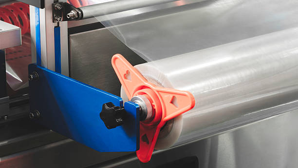 istock Automatic polyethylene plastic bag production machine with lighting effect. Close-up of the roller of the plastic bag production machine in the light blue scene. product packaging concept 2251454547