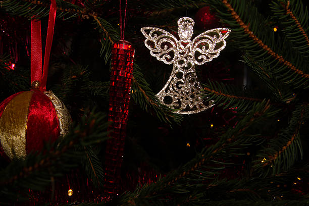 Creative Christmas decoration - a small wooden angel hanging on a branch