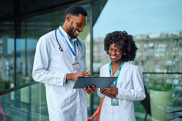 istock Doctors smiling and consulting tablet, discussing patient health 2251455236