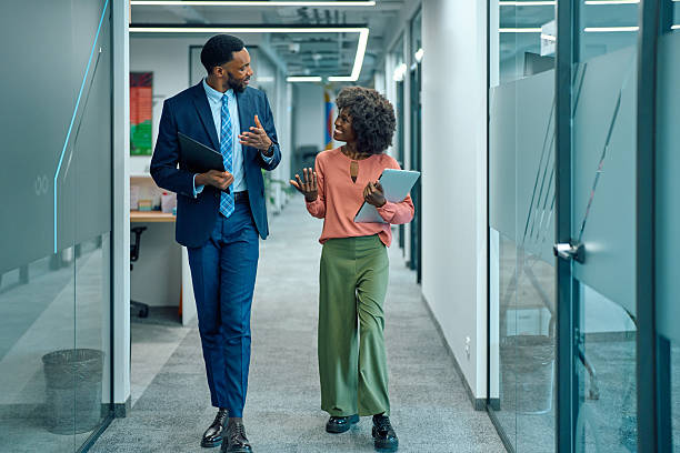 istock Business colleagues walking and talking along office corridor 2251455996