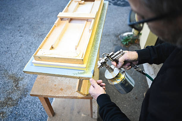Painter painting with spray gun. Dark background.Similar images: