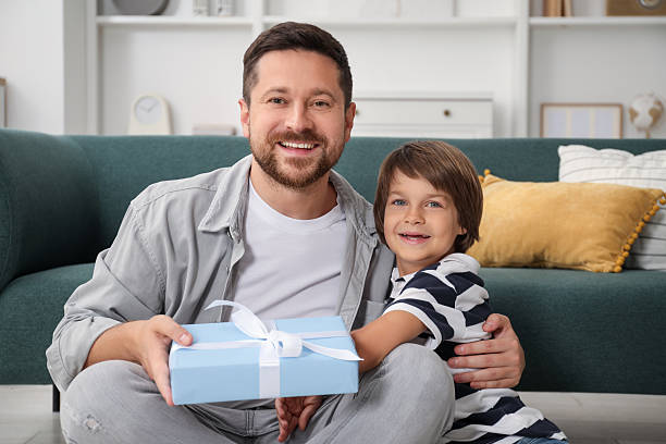 istock Happy Father's Day. Son giving his dad gift at home 2251463689