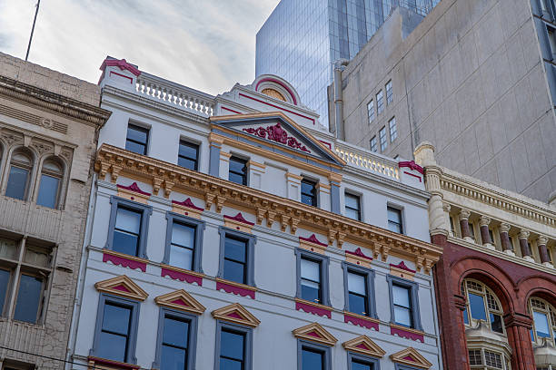 istock Architectural juxtaposition: ornate historical building stands between aged structure and modern skyscrapers against a cloudy sky 2251466089
