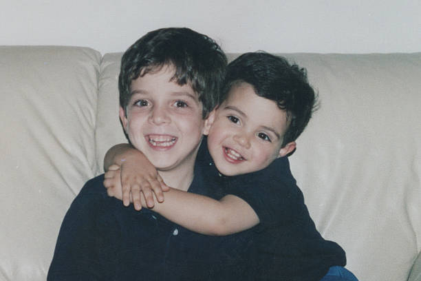 istock Image taken in 1980s: little male siblings embracing 2251469619