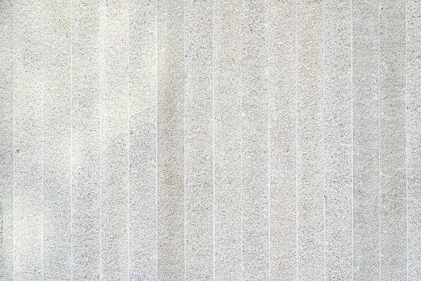 Light Gray Granite Wall Texture with Vertical Grooves. for design projects, backdrops, and themes related to construction, luxury materials, and contemporary architecture.
