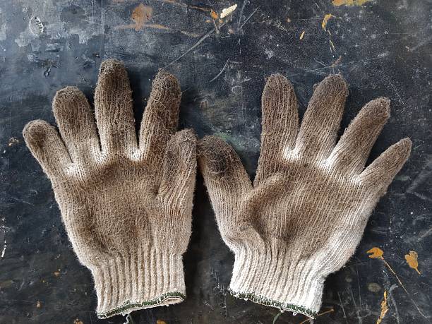 a pair of used gloves on a black mat
