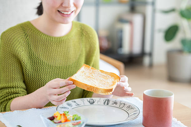 Young woman eating bread for breakfast