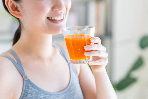 istock Young woman drinking vegetable juice 2251473475