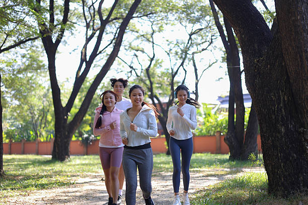 istock Group of Young Adults Jogging in Park 2251474603