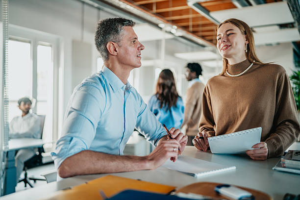 istock Two coworkers discuss a project in a modern coworking space in Berlin during a busy workday with diverse professionals engaging around them 2251475108