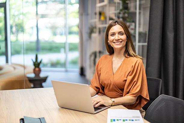 istock Confident woman smiling at her laptop in office setting 2251475687