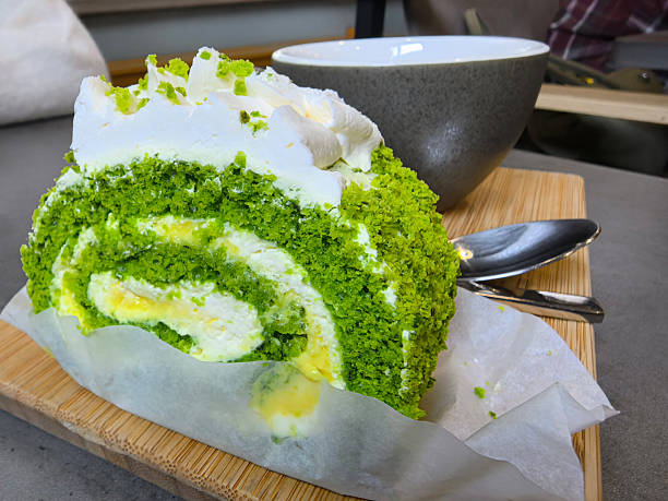 Delightful green roll cake served with a cup in a cozy cafe setting