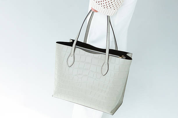 istock light textured leather woman's bag, minimalist design on a light environment 2251479665