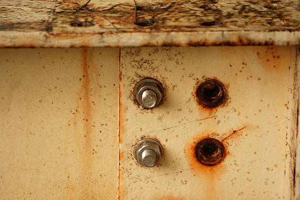 Close-up of a rusty metal surface with bolts showing signs of corrosion and decay