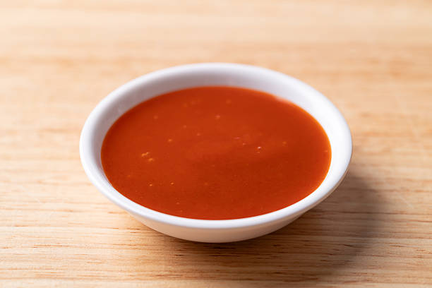 istock Sriracha sauce in a bowl on wooden background 2251482184