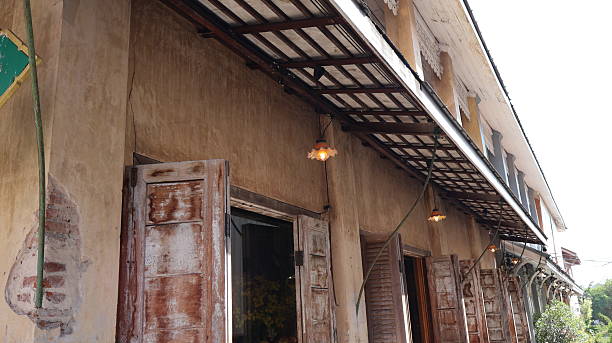 istock An old building with weathered wooden shutters and doors. It features a rustic aesthetic with peeling paint in various areas. 2251492348