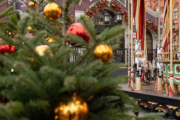 istock Carousel with white horses and decorated tree at festive market 2251496884