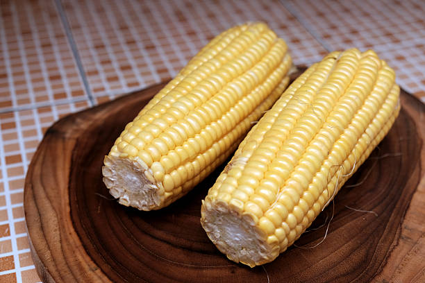 istock Fresh raw yellow ​​sweet corn on a wooden chopping board. 2251499771