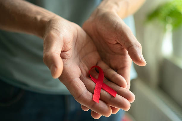 istock Man Presenting Red Ribbon for World AIDS Day 2251499846