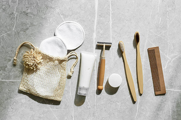 istock Hygiene products as bamboo toothbrushes, toothpaste, reusable pads, safety razor on grey marble background with natural light, eco-friendly items for self care, zero waste concept. Minimal top view 2251501933