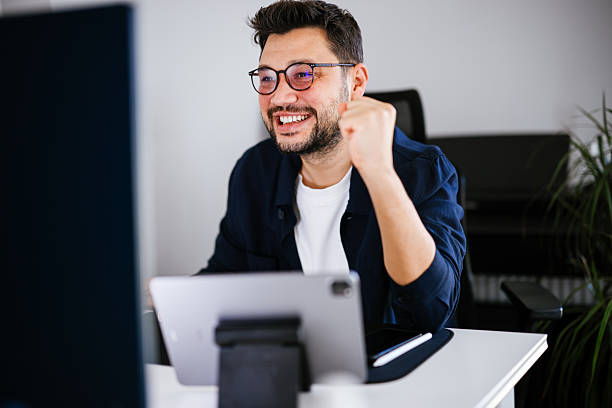 istock Excited young man looking at laptop celebrating online victory 2251502872