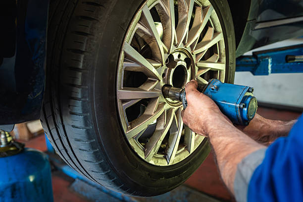 istock Mechanic changing car wheel in workshop garage 2251510472