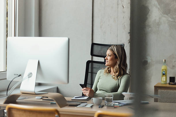 istock Female entrepreneur using mobile phone in a modern office. 2251512341