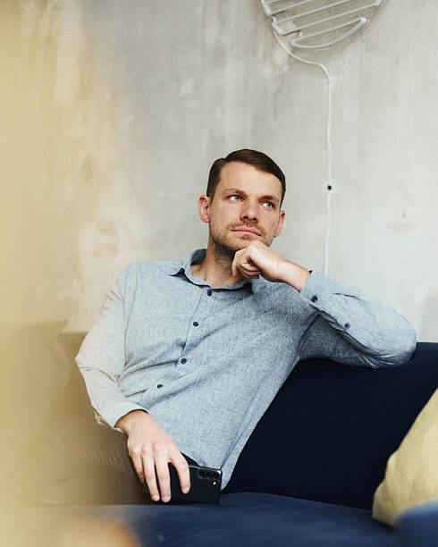 istock Thoughtful businessman relaxing on sofa in casual office. 2251512353