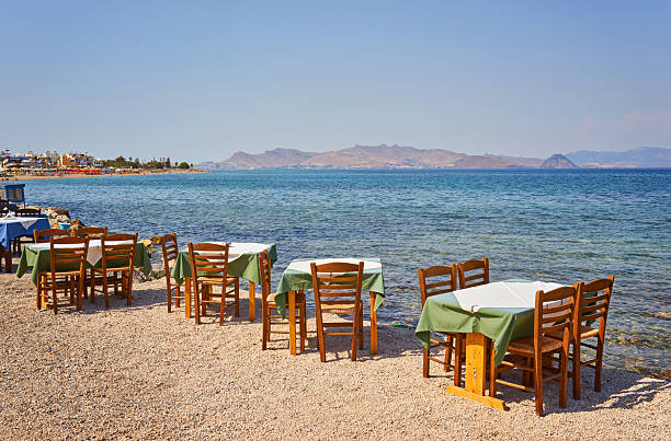 istock Greek beach with traditional blue tables and chairs 2251512659