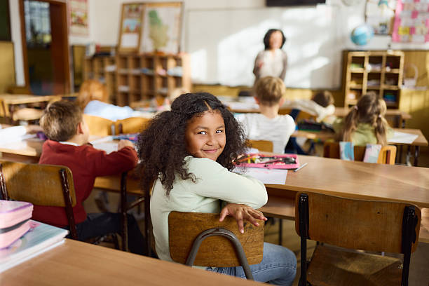 istock Smiling black schoolgirl on a class in the classroom. 2251512832