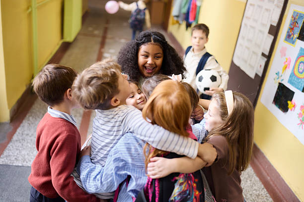 istock Happy students greeting on the first day of elementary school in a hallway. 2251513070