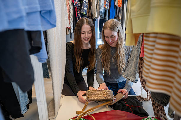 istock Women choosing clothes together in secondhand store 2251514338