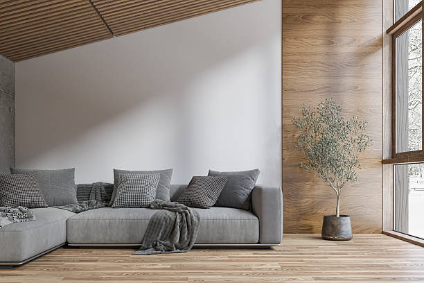 istock A cozy modern interior in a log cabin, with an olive tree placed beside large windows with a snowy outdoor view, a gray sofa in front of an empty white wall, partly wooden wall and copy space 2251515843