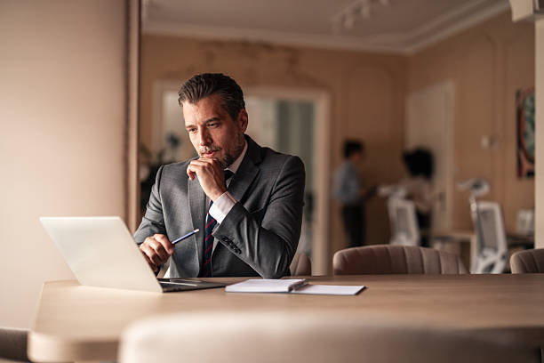 istock Professional Man Working on Laptop in a Modern Office Environment 2251515870