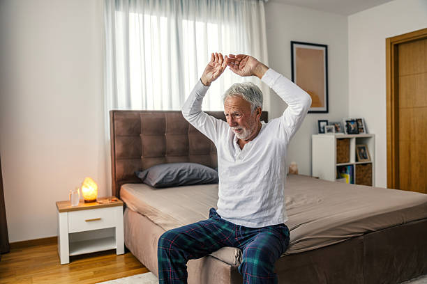 istock Senior man waking up stretching in pajamas 2251518416