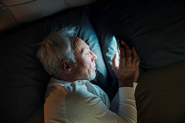 istock Senior man using smartphone in bed at night 2251518669