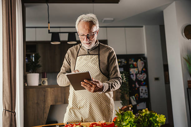 istock Senior man cooking healthy meal using digital tablet recipe 2251518760