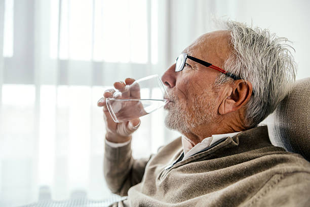 istock Senior man drinking water staying hydrated at home 2251518992