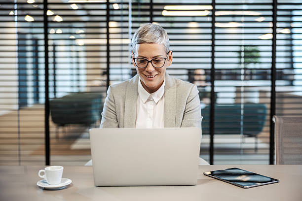 istock Mature businesswoman smiling while working with laptop 2251519473