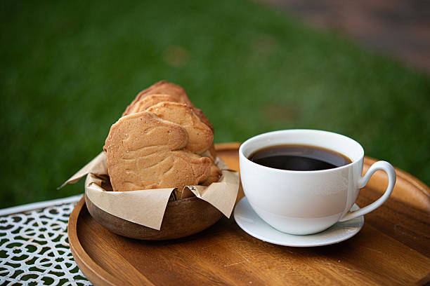 Coffee cup black hot breakfast cookie biscuit snack wooden tray gentle morning coffee cup with black hot breakfast cookie biscuit snack wooden tray outdoors, warm aroma and calm mood garden setting