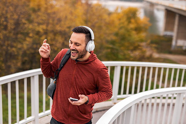 istock Man Enjoying Music Outdoors on a Scenic Autumn Walk 2251527491