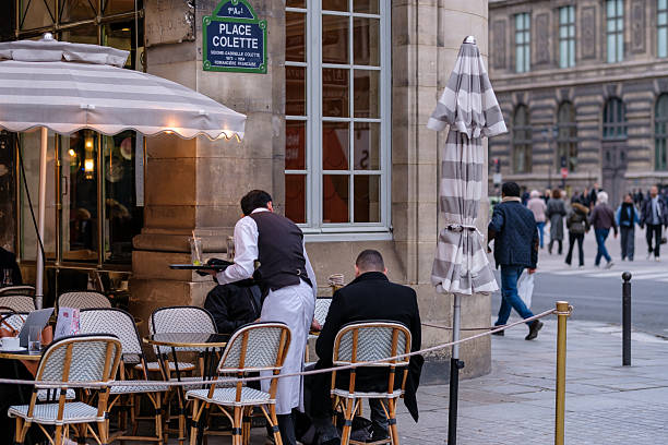 Vincennes, France - December 10, 2025 : View of typical cafe and a waiter serving a table with customers at the place Colette in Paris France