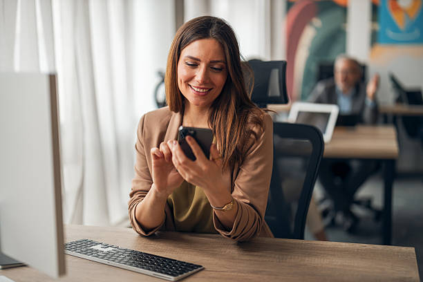 istock Business Professional Checking Mobile Phone in Modern Office Workspace 2251530972