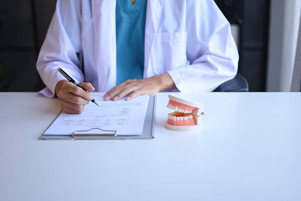 istock Dentist working in office writing diagnose oral health issues. 2251531937