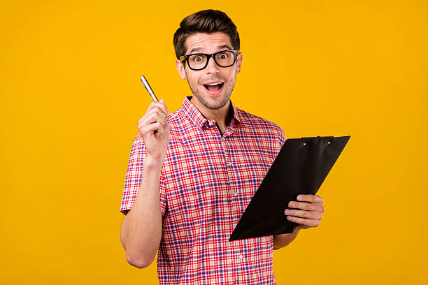 istock Portrait of attractive cheerful guy geek writing list idea creative solution isolated over bright yellow color background 2251534154