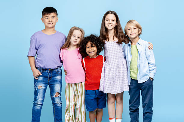 istock Diverse group of smiling elementary school children embracing friendship and unity 2251535551