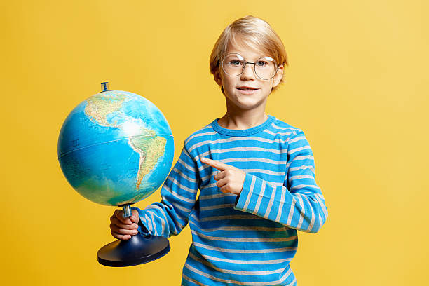 Hand touching globe on white background. The globe is marked with a black line, possibly planning a coast to coast journey from New York to Los Angeles.